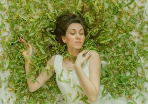 Self portrait in a background full of linden tree flowers.