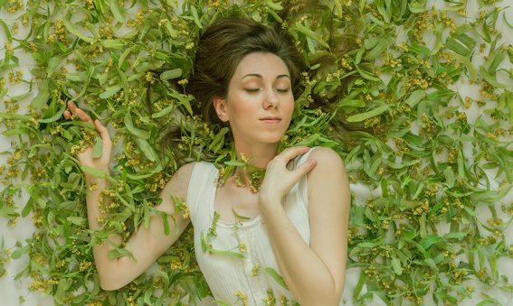 Self portrait in a background full of linden tree flowers.